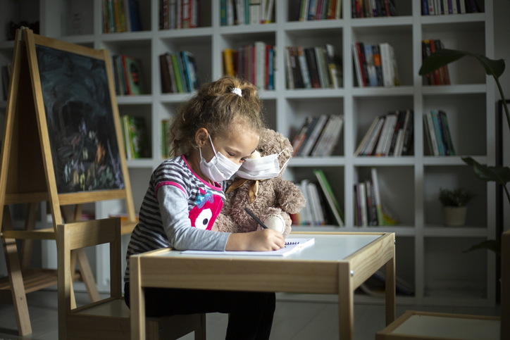 Little girl taking online courses in living room