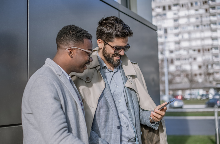 Two businessman looking at smartphone