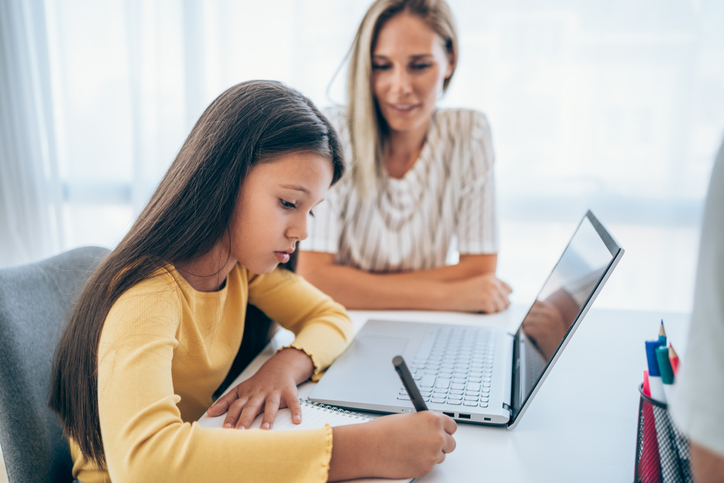 Mother and daughter studying online at home.
