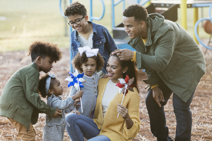 Large mixed race family at playground